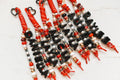 Six matching Lucky Loop bag charms in red and black team colors, each beaded with a different name