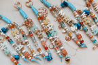 Close-up of coastal blue name charms showing the pearl, shell and tassel beadwork