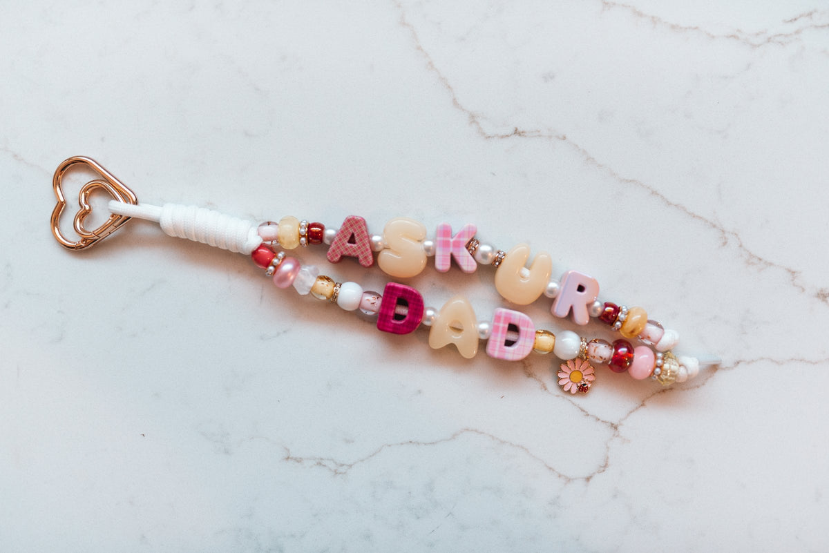 Ask Your Dad 2-strand loop in pink plaid and cream with ASK UR DAD letter beads, a pink daisy and ladybug charm and a rose gold heart clasp
