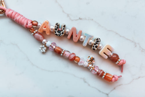 Auntie 2-strand loop in peach, pink and leopard with AUNTIE letter beads, a pearl flower charm and a little tiger charm on a pink cord