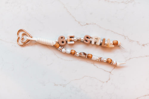 Be Still 2-strand loop in cream and caramel neutrals with BE STILL letter beads, wood beads, pearls and a rose gold heart clasp