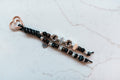 Gigi 2-strand loop in black, espresso and leopard with GIGI letter beads, a gingham heart charm and a rose gold heart clasp
