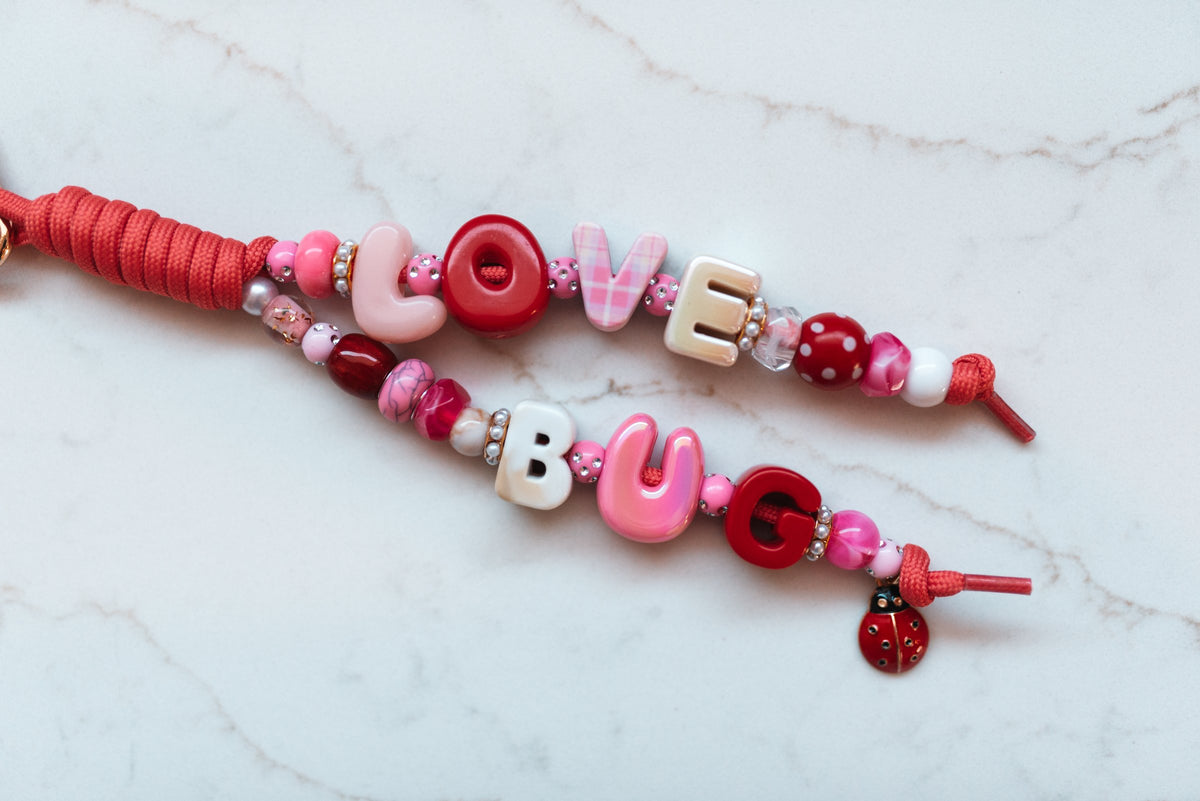 Love Bug 2-strand loop in cherry red and pink with LOVE BUG bubble letters, rhinestone and polka dot beads and an enamel ladybug charm