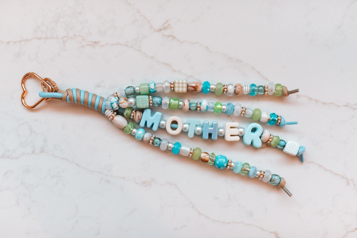 Mother Luxe loop laid flat on marble, showing all four beaded strands