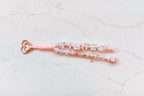 Pilates Princess loop — pink and pearl 2-strand bag charm spelling PILATES and PRINCESS on a rose gold heart clasp